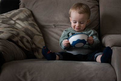 Boy sitting on sofa at home