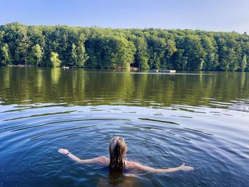 Young woman swimming in the lake on a sunny summer day