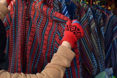  woman choosing clothes from rack at store