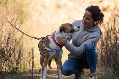 Side view of woman with dog on field