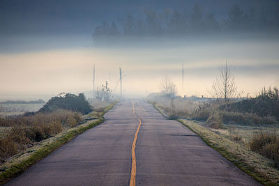 Fog hovers above road leading to the unknown