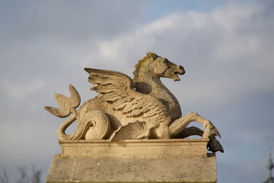Low angle view of lion statue against sky