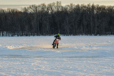 Man with umbrella on snow covered field