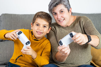 Little kid and his grandmother playing video games