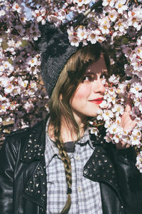 Portrait of woman standing by flower tree