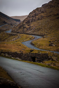 Road by mountain against sky