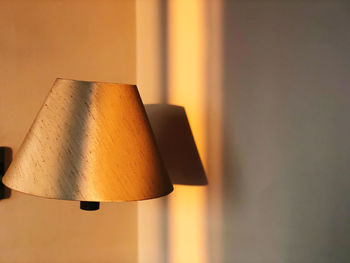 Close-up of electric lamp against wall at home