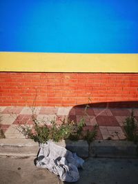 View of red wall and house against blue sky