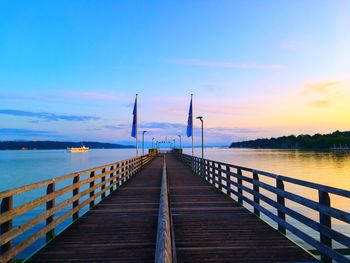 Pier over sea against sky during sunset