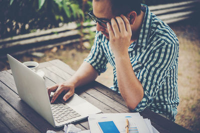 Man using laptop while sitting at table