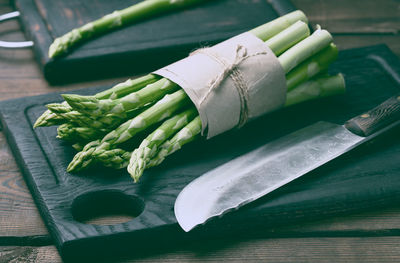 Bunch of fresh raw asparagus on a wooden black kitchen board, a healthy product