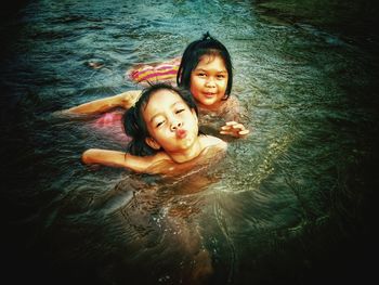 High angle portrait of smiling girl swimming in water