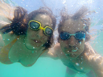 Close-up portrait of couple swimming underwater