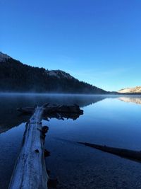 Scenic view of lake against clear blue sky