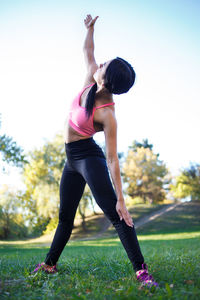 Young girl practices yoga in the park on the grass.