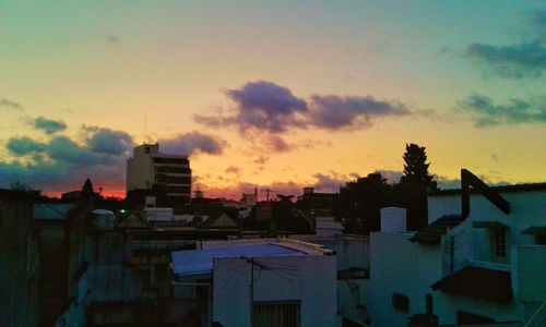 Silhouette cityscape against sky at dusk