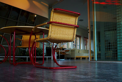 Empty chairs and tables in illuminated building