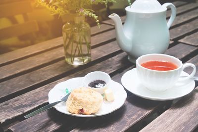 Close-up of tea and muffin served on table