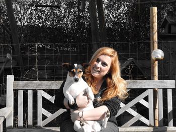 Happy woman playing with dog at backyard