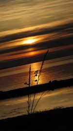 Silhouette electricity pylon against sky during sunset