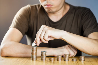 Close-up of a young woman with hand on stack of table