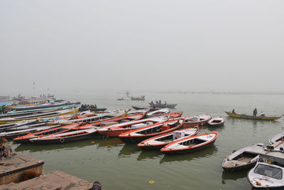 Boats moored in sea against clear sky