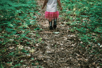 Low section of woman standing on field