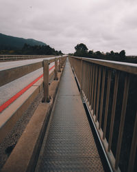 Empty footbridge against sky