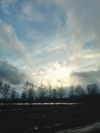 Scenic view of field against cloudy sky