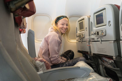 Portrait of mid adult woman sitting at airplane