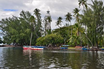 View of boats in water against cloudy sky