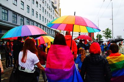 Rear view of people on street in rain