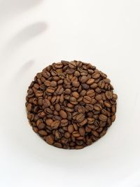 High angle view of coffee beans against white background