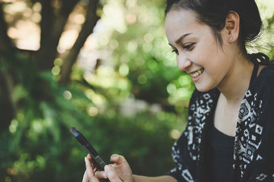 Young women smiling when her looking mobile phone