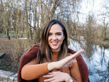 Portrait of happy young woman in winter clothes in park.