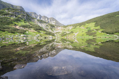 Still crystal clear alpine tarn reflecting its surroundings like a mirror, slovakia, europe
