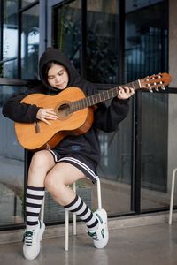 Portrait of woman playing guitar