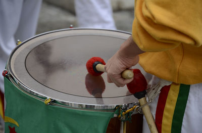 Midsection of man playing drum