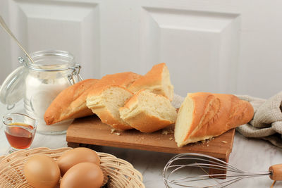 Sliced french baguette with crumbs on white background. 