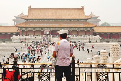 Rear view of people standing outside temple