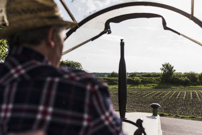 Farmer on tractor next to field