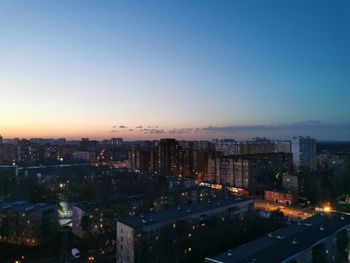 High angle view of illuminated city against sky at dusk