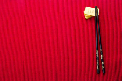 Directly above shot of gold bars and chopsticks on maroon textile