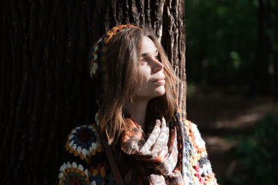 Portrait of woman with tree trunk in a crochet sweater
