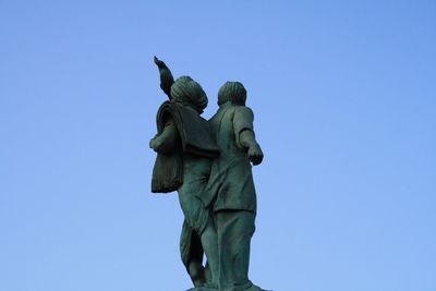 Low angle view of statue against clear blue sky