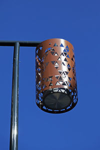 Low angle view of electric lamp against blue sky