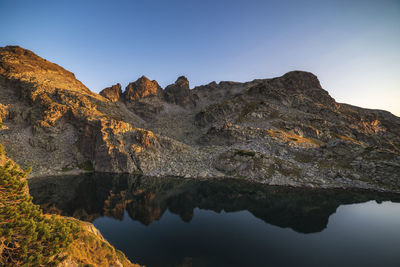 Scenic view of lake and mountains against clear sky