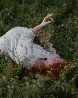 High angle view of young woman sitting on field