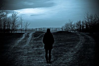 Rear view of woman walking on road