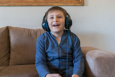 Happy boy sitting on sofa at home